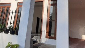Un bâtiment doté d’un toit plat, de grandes colonnes et d’un escalier menant à une porte.