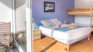 A bedroom with a bunk bed, a bedside table, a lamp, and a framed picture on the wall. - L'Ermitage by Interhome (Saint Brevin les Pins)