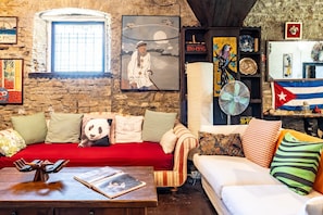A cozy living room with a stone wall, a red sofa, a white sofa, and a wooden coffee table. - Villa "Il Rancho Grande" with Private Pool, Private Terrace & Wi-Fi (Città di Castello)