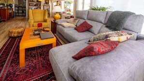 A living room with a sofa, armchair, and coffee table. There is a bookshelf and a lamp in the background. - Millenium by Interhome (Premià de Dalt)