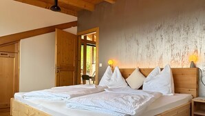 A wooden bed with white linens, a wooden headboard, and two bedside lamps. - Apartment "Zwick Valmeina" with Panoramic Views, Balcony & Shared Garden (Mals)