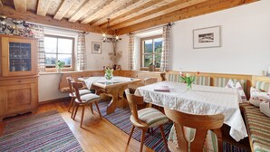 A wooden interior with a dining table, chairs, a bench, and a window with curtains. - Apartment "Zwick Valmeina" with Panoramic Views, Balcony & Shared Garden (Mals)