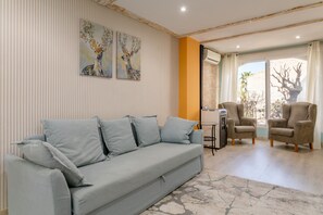 Un salon comprenant un canapé, deux fauteuils, une table basse et des œuvres d’art accrochées au mur.