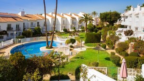 A resort with a swimming pool, palm trees, and white buildings with red-tiled roofs. - Jardines de Nerja by Interhome (Nerja)
