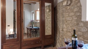 Un meuble en bois avec des miroirs, une bouteille de vin et des verres sur une table.