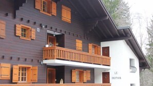 A multi-story building with wooden balconies and shutters, labeled "LE DAUPHIN". - Dauphin 7 by Interhome (Villars)