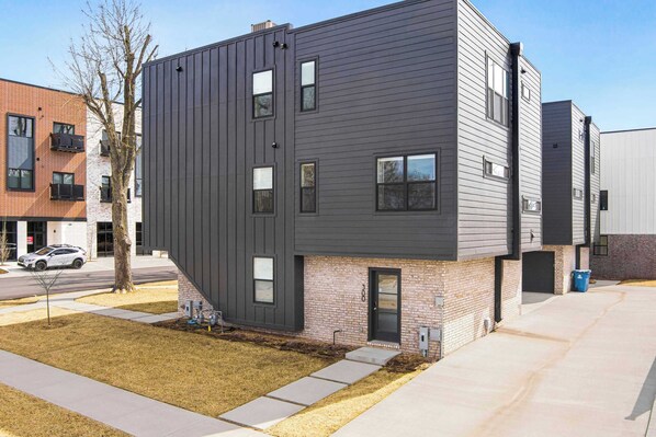 A modern multi-story building with a flat roof, large windows, and a brick facade.