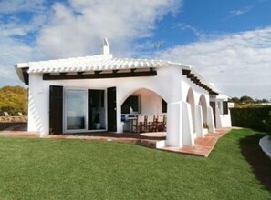A modern white house with a patio, large windows, and a covered outdoor area. - Villa 'Bini Sek' with Sea View, Private Terrace and Air Conditioning (Binibèquer)