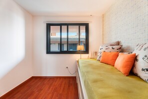 Een kamer met een bed, een raam en een wand met behang.