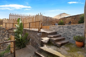Outdoor stone steps, a wooden fence, and a stone wall.