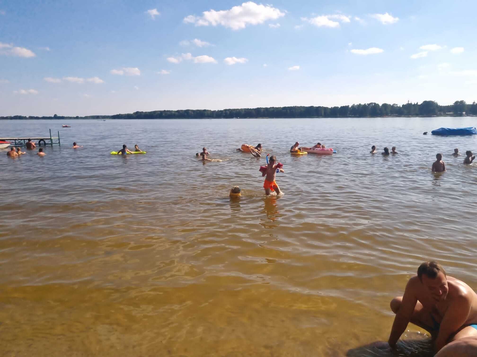 Ein See mit Schwimmern und Wassersportlern auf unterschiedlichen Booten.