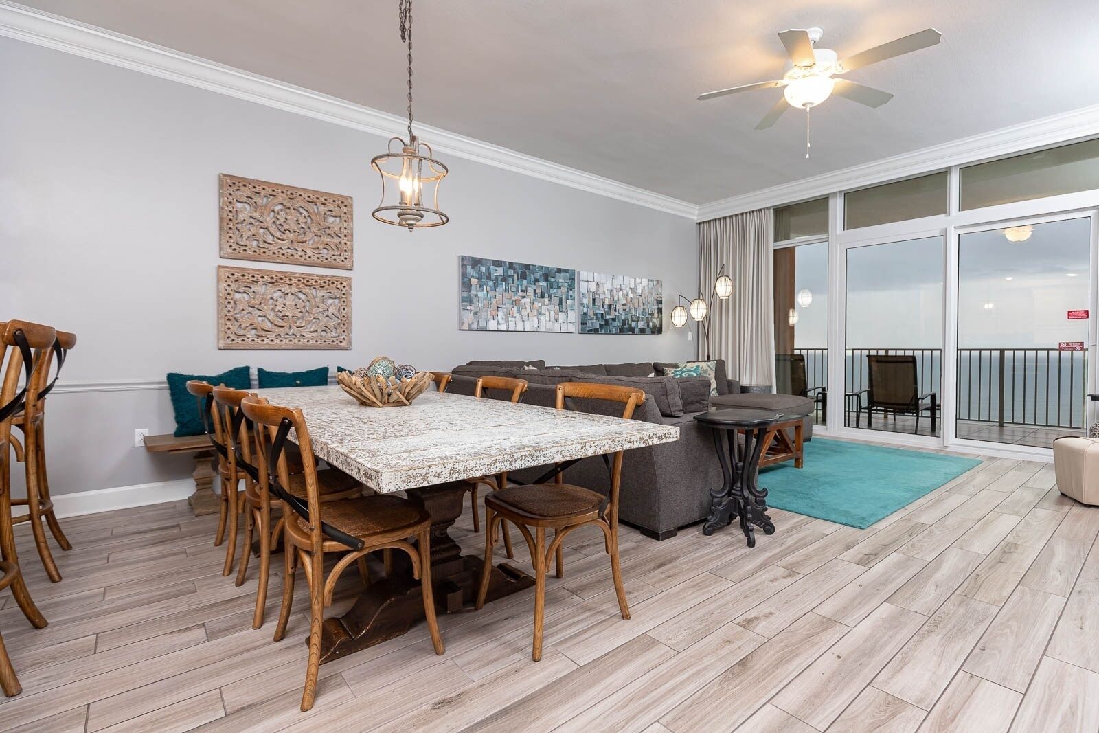 Un grand espace de vie comprenant un coin repas avec une table, des chaises et un canapé. Il y a également un balcon avec vue.