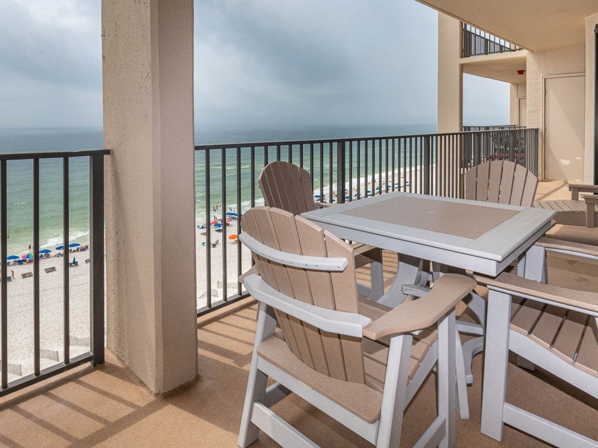 Un balcon avec vue sur la plage, comprenant une table et des chaises.