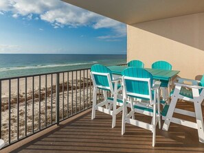 A balcony with a view of the ocean, featuring a table and four chairs. - Phoenix X by Brett Robinson Vacations (Orange Beach)