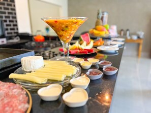 Una zona de bar con una selección de quesos, embutidos y salsas.
