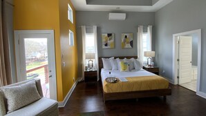 A bedroom with a large bed, a sofa, a ceiling fan, and a view of the outside. -  Stay in Style Where the Musicians Live 6-beds, 4-bedroom, 3-bath   (Nashville)