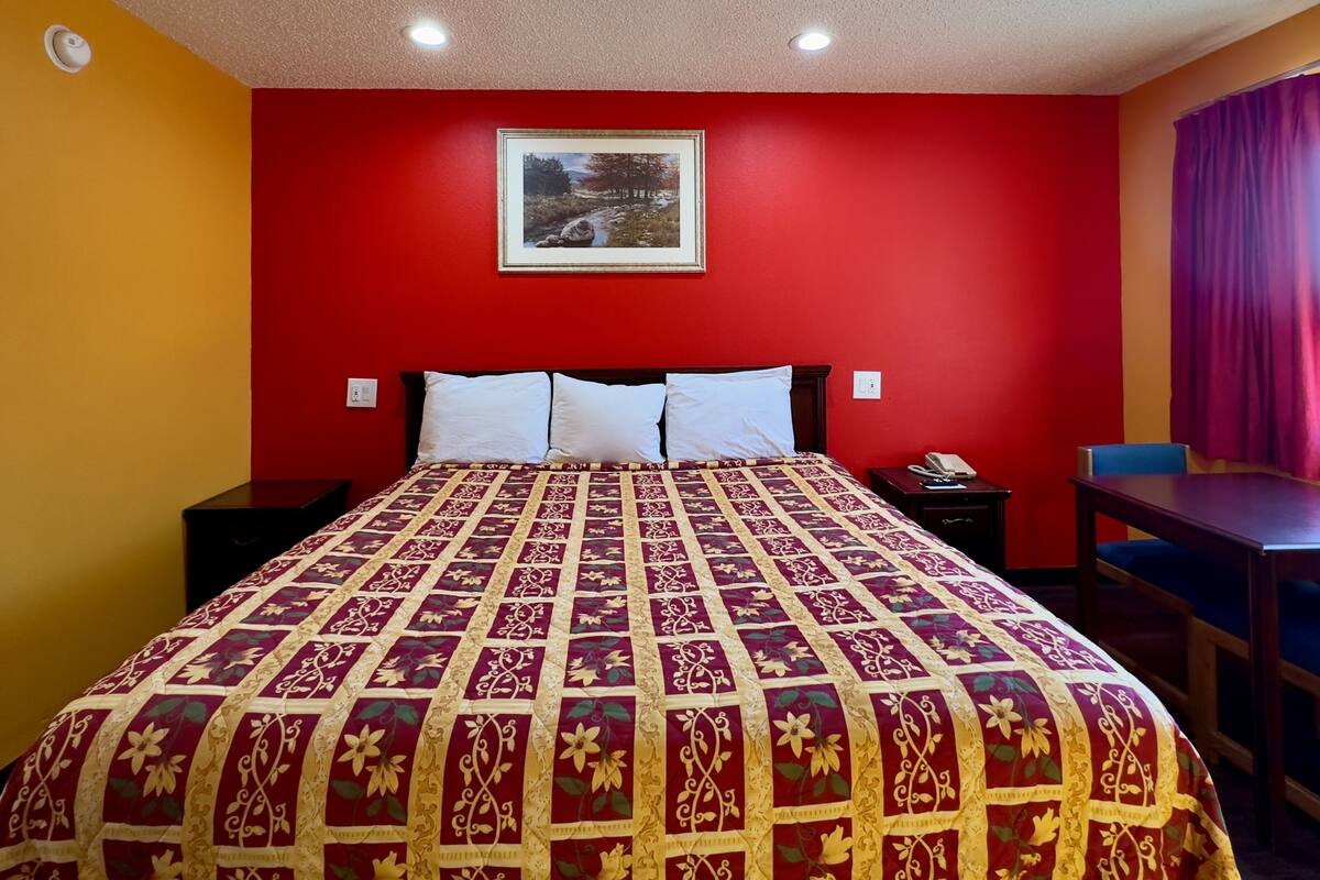 Une chambre d’hôtel avec un grand lit, un bureau et une chaise.