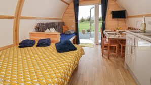 A cozy, single-room accommodation with a bed, a small desk, a dining table, and a TV. - Mischief (Driffield)