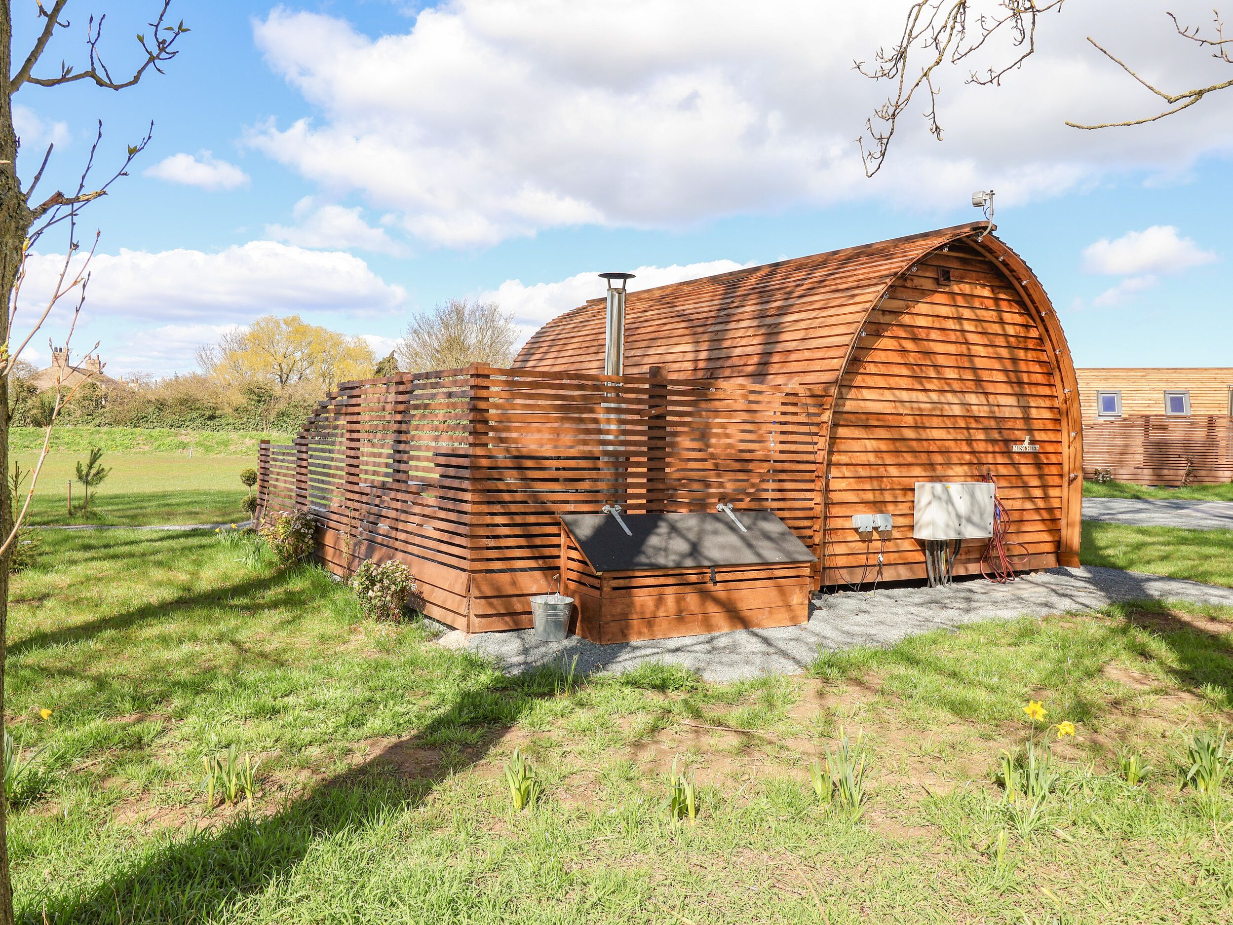 A wooden structure with a sloped roof, a small attached shed, and a concrete foundation.