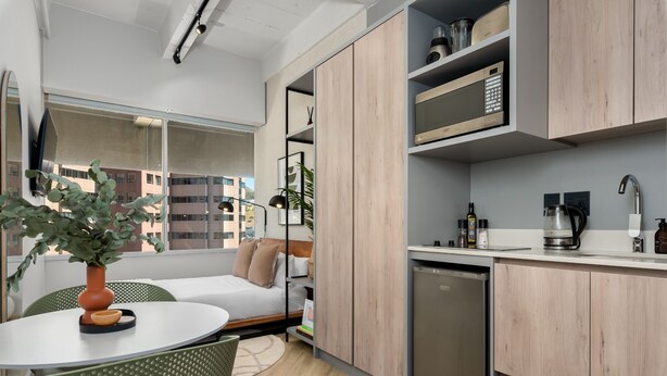 Un appartement moderne comprenant une cuisine, un coin repas et un lit.