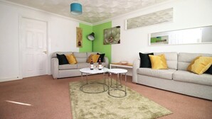Un salon avec deux canapés, une table basse et un tapis.