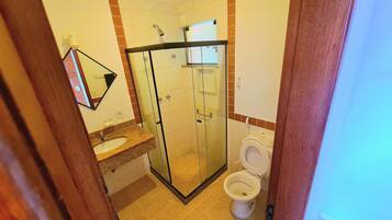 Une salle de bain avec une douche à parois de verre, un lavabo et des toilettes.