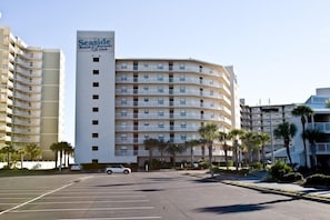 Un hotel de varios pisos con un letrero que dice "Seaside Beach & Club".