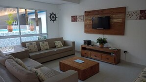 Un salon moderne comprenant un canapé, une table basse, un téléviseur et des objets de décoration.