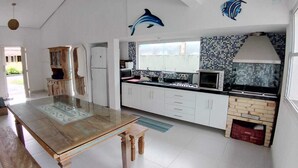 Une cuisine avec des meubles blancs, un pare-feu en carrelage et un four encastré.