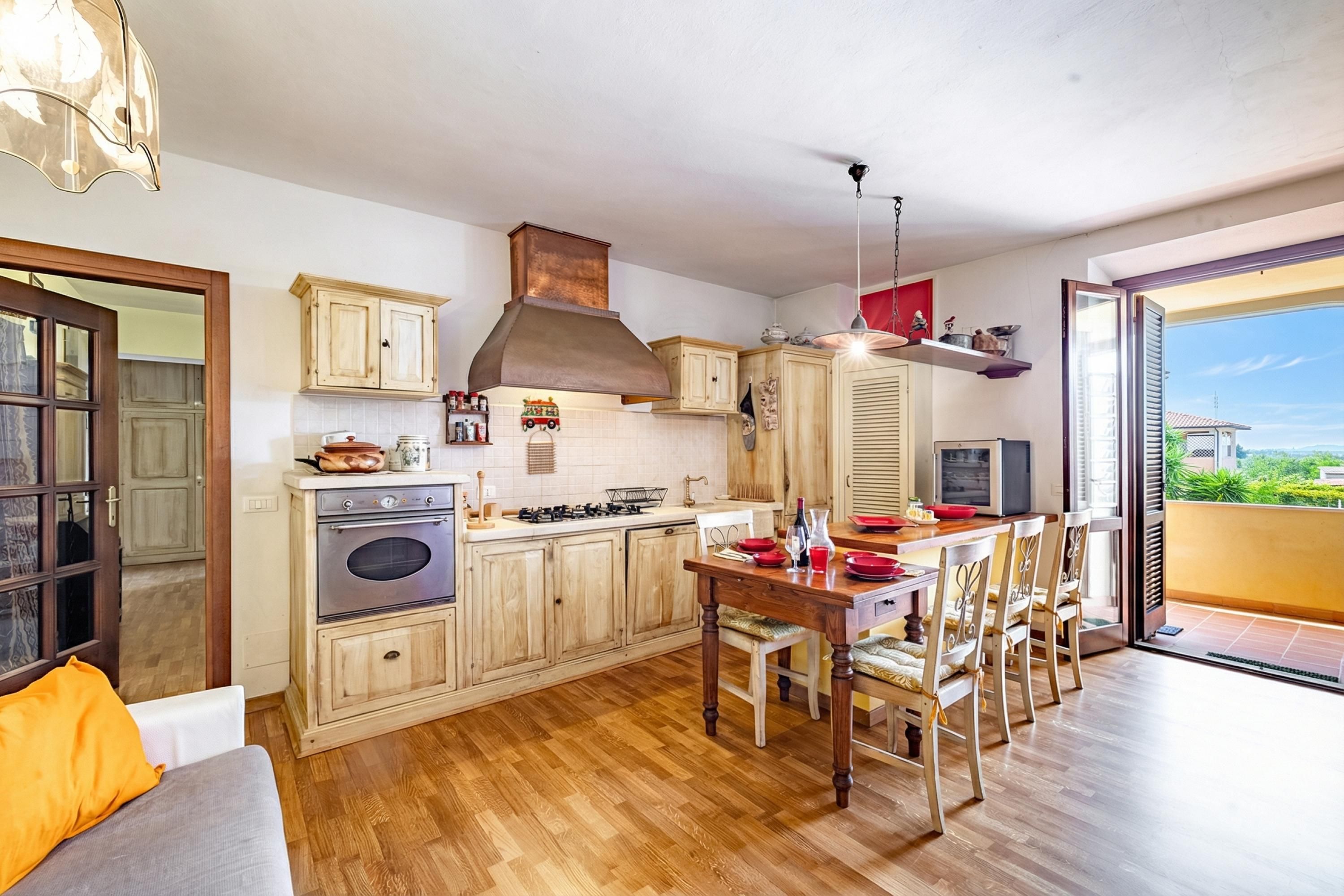 Une cuisine avec des meubles de rangement en bois, une cuisinière et un coin repas avec des chaises.