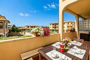 A dining table set outdoors with a view of surrounding buildings. - Casa di Allegra Terme di Venturina (Campiglia Marittima)