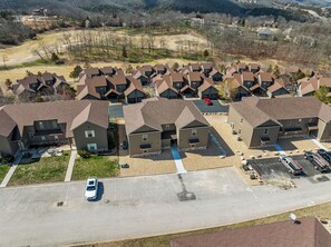 An aerial view of a residential area with multiple two-story houses, each featuring a garage and a driveway. - Level Up Lodge, Level Up Lodge - Pet Friendly (Reeds Spring)