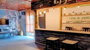 A bar area with a counter, two stools, and a mural on the wall. - Minimalist private studio @ Eau Gallie Downtown, spacious in size of 650 sqft.  (Melbourne)