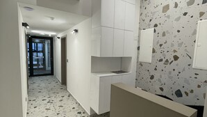 A hallway with a terrazzo floor, white walls, and a reception desk. - Seascape Luxury Rooms (Split)