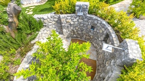 A stone structure with a wooden door, surrounded by greenery. - Resort Ravenna - Villa Cavaliere (Massa Lubrense)