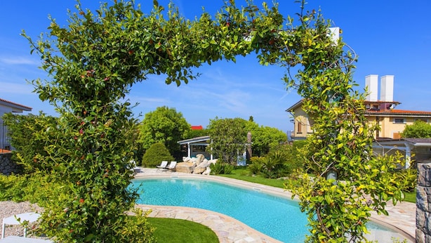 A swimming pool surrounded by lush greenery and stone pathways. - Resort Ravenna - Villa Cavaliere (Massa Lubrense)