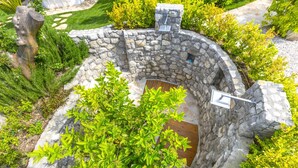 A stone structure with a wooden door, surrounded by greenery. - Resort Ravenna in Massa Lubrense (Massa Lubrense)