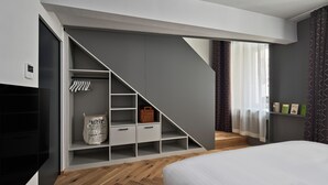 Un dormitorio moderno con armario empotrado, suelo de madera y una cama.