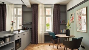 Una cocina moderna con comedor, suelo de madera en espiga y vistas a la ciudad a través de grandes ventanales.