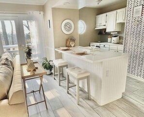 A modern kitchen with a central island, white cabinetry, and a herringbone-patterned wall. - Luxe Villa- mins from Mohegan Sun with fireplace, jacuzzi, sauna/pools, and spa (Norwich)