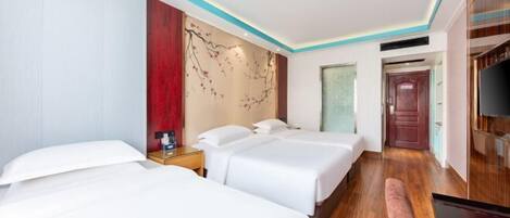 A hotel room with two beds, a wooden floor, a wall with a decorative panel, and a television.