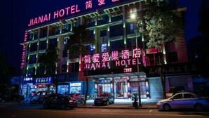 Een hotel met een opvallend bord waarop in felroze letters 'JIANAI HOTEL' staat.