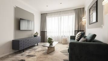 A modern living room with a sofa, a coffee table, and a TV mounted on the wall.