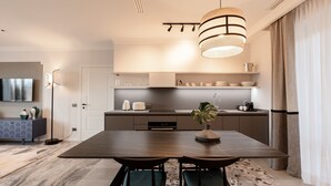 Una cocina moderna con una isla grande, electrodomésticos integrados y una lámpara colgante.