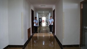 A long, narrow hallway with a polished floor and white walls. - Kingdom Hotel (Panjin)