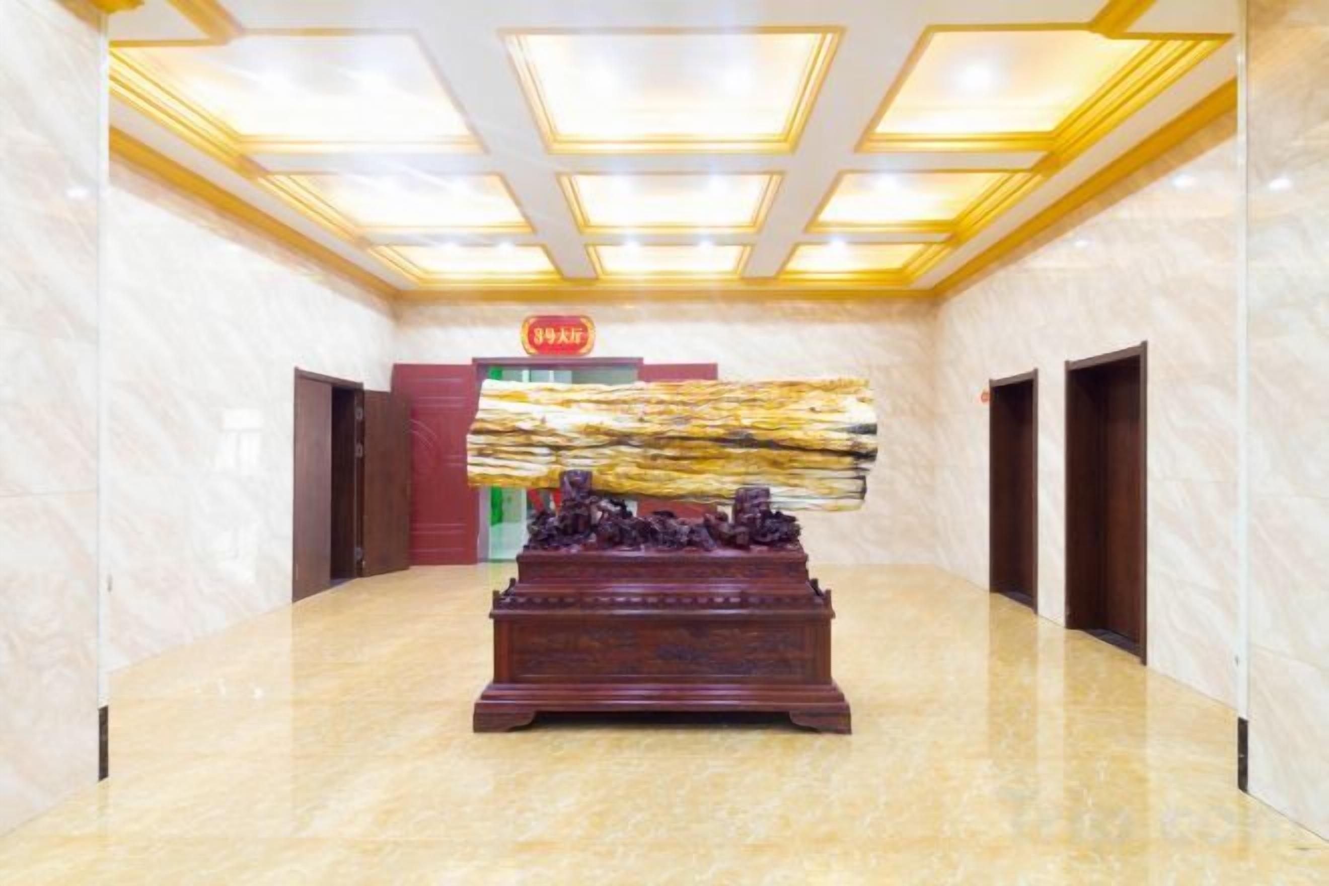 A hotel lobby with a marble floor, a reception desk, and a reception area.