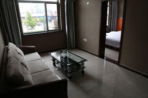 Habitación de hotel con una mesa de centro de vidrio, un sofá y una cama.