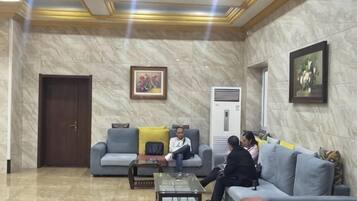A lobby with a marble floor, a sofa, a coffee table, and a door.
