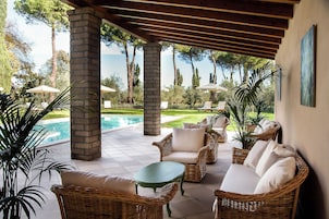 Una piscina al aire libre, sombrillas, sillones reclinables de piscina