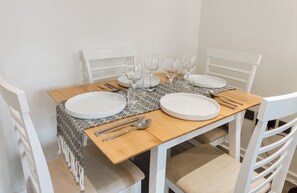 Enjoy meals with family and friends at this stylish dining table for four, set with fine china and comfortable seating.